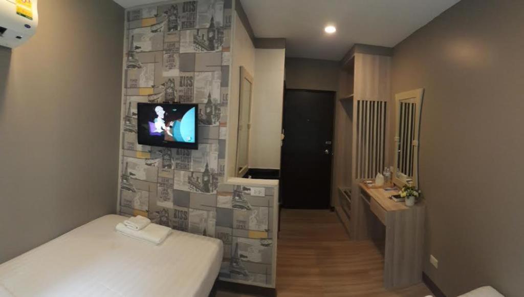 a room with a bed and a tv on a wall at YWCA Hotel Bangkok in Bangkok