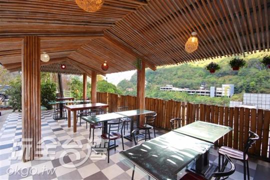 un patio con mesas y sillas y una valla en Lushan Xiangting Tea Homestay, en Renai