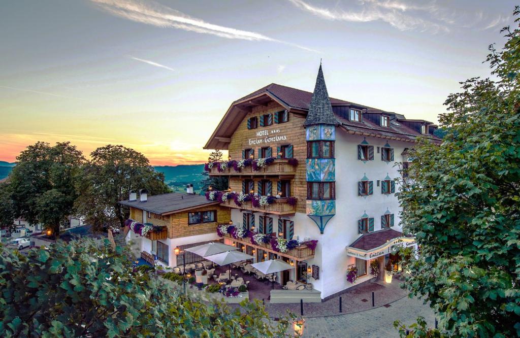 a hotel in the mountains with a building at Hotel Enzian Genziana in Siusi