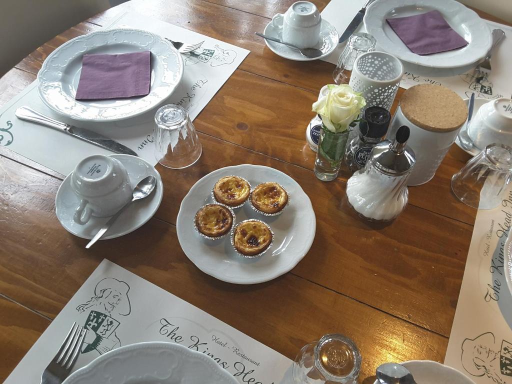 una mesa de madera con platos de comida. en Hotel Restaurant The Kings Head Inn en Voeren