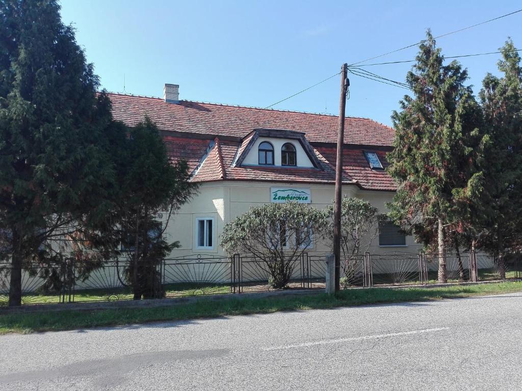 een groot wit huis met een rood dak bij Penzión Žemberovce in Dolné Žemberovce