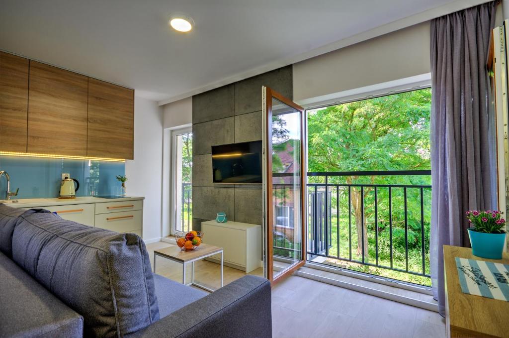 a living room with a couch and a large window at Apartamenty Nautica blisko plaży in Niechorze