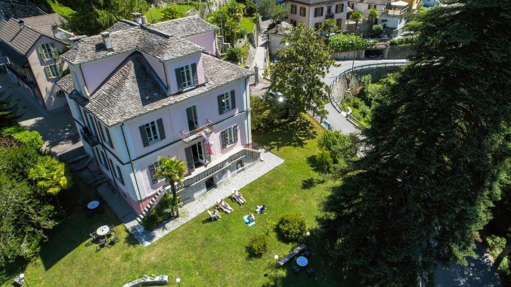 una vista aérea de una casa grande con gente en el césped en Wild Valley Hostel - Villa Edera en Auressio