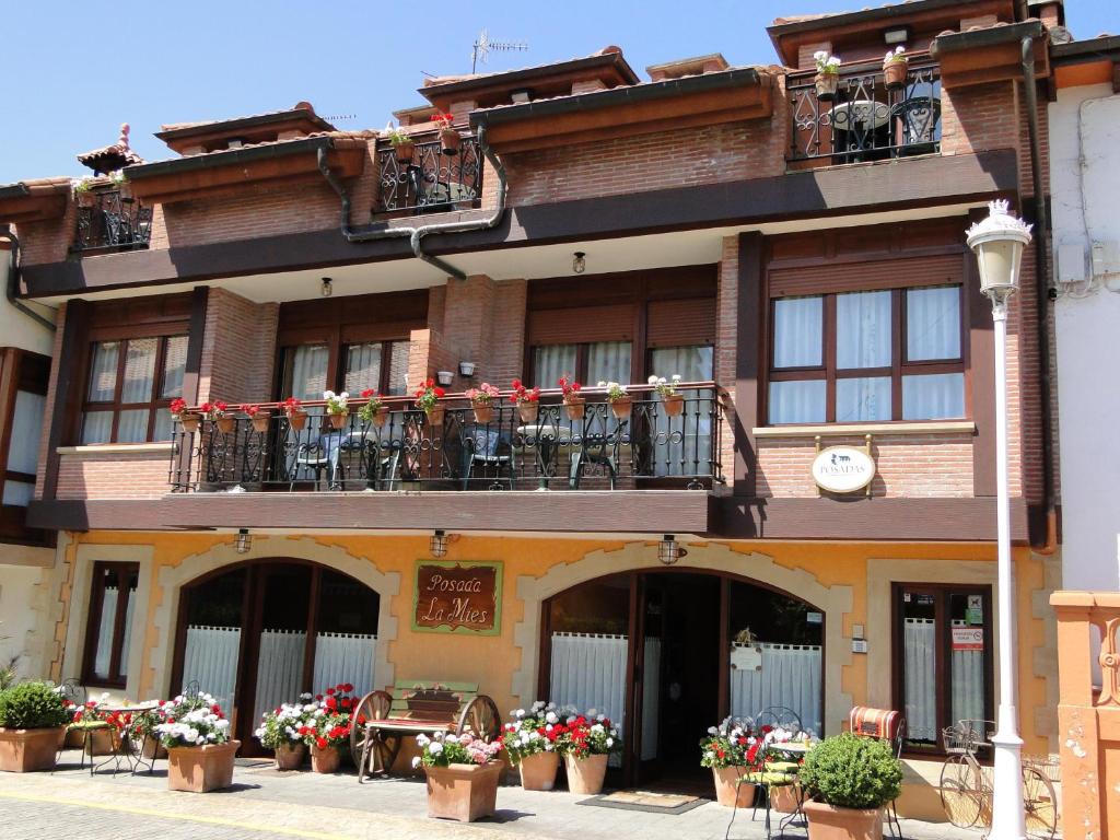 a building with flowers on the balconies of it at Posada La Mies in Noja