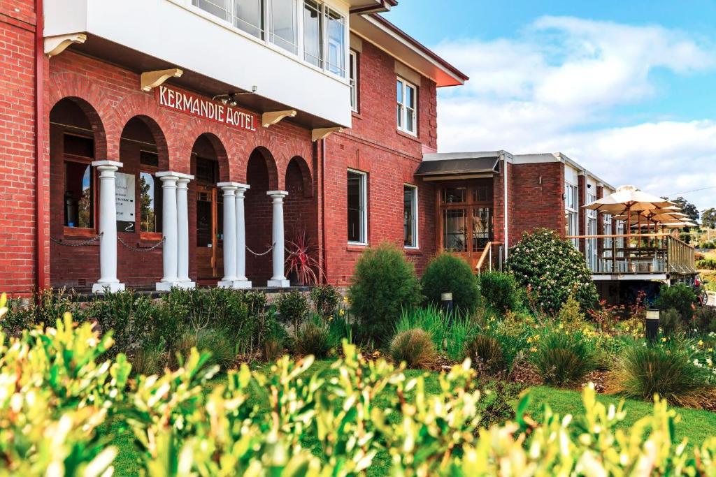 a red brick building with white columns at Kermandie Hotel in Port Huon
