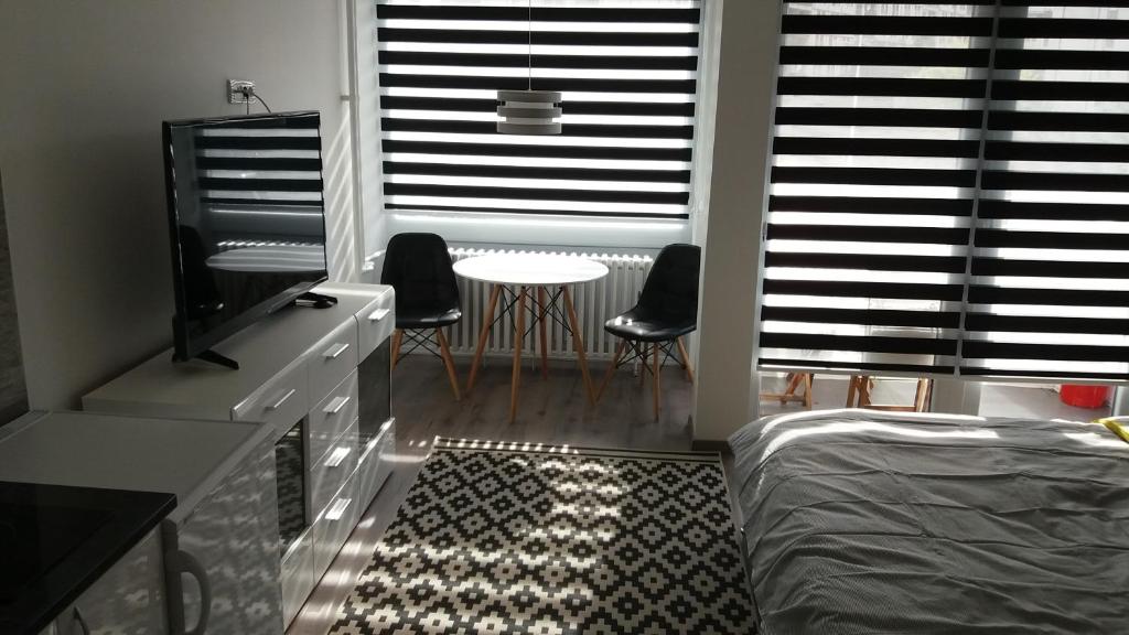 a bedroom with a bed and a table and chairs at White City 1 Apartment in Belgrade