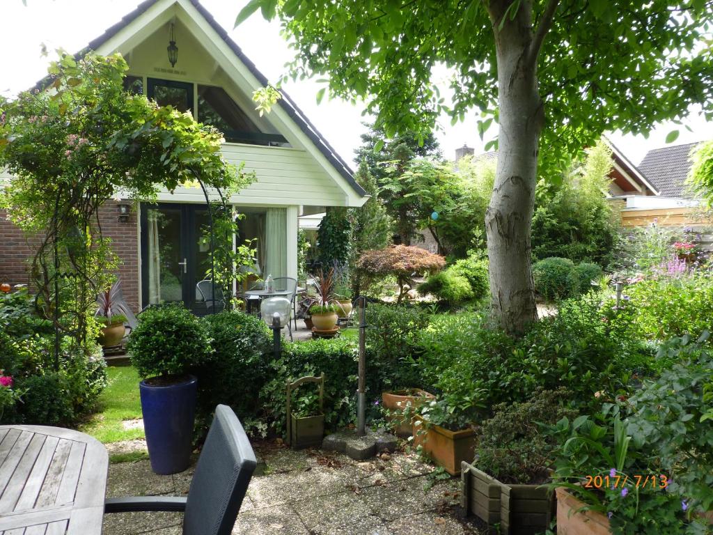 einen Hof mit einem Haus mit Pflanzen und einem Baum in der Unterkunft Wiersse 68 in Doetinchem