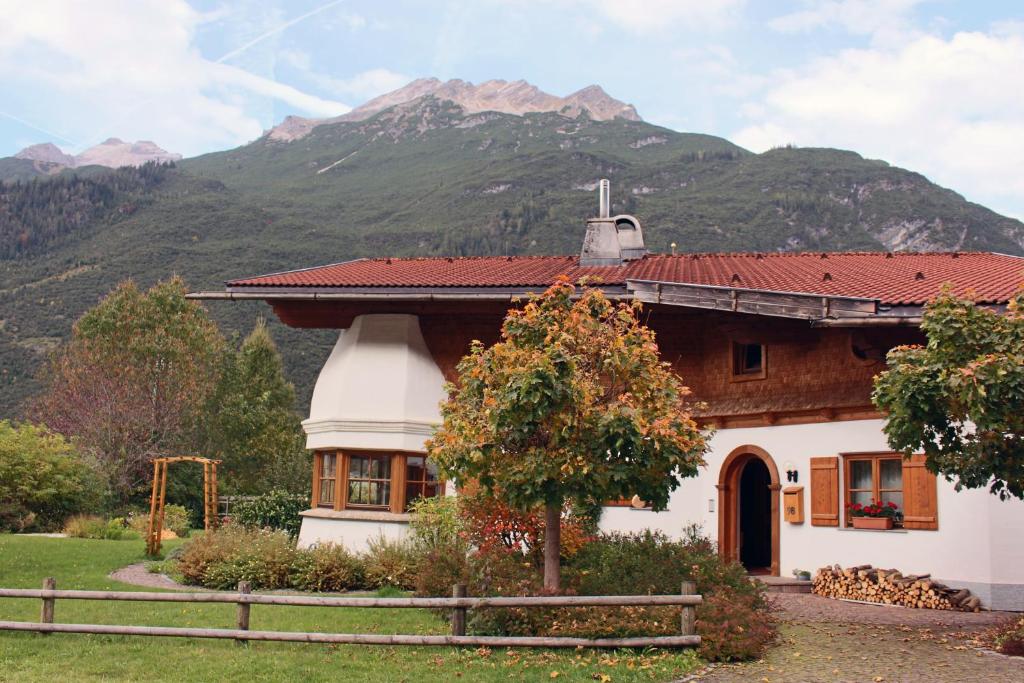 a house with a mountain in the background at Ferienwohnung Sonja in Elmen