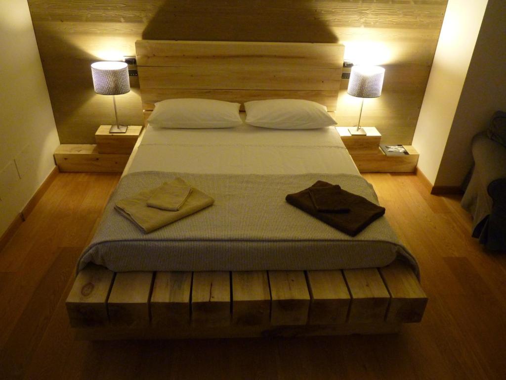 un grande letto in una camera da letto con due lampade di Ca'Luna a Mondovì