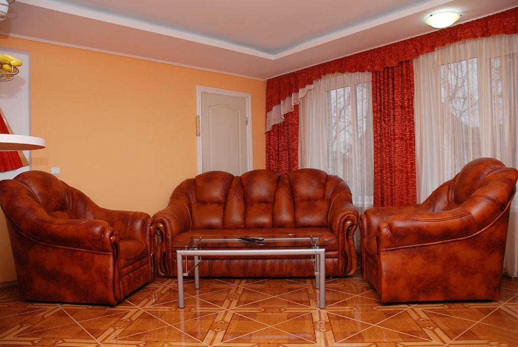 2 sillas de cuero y una mesa de centro en la sala de estar. en VIP Apartments 11 Kiev en Vyshhorod