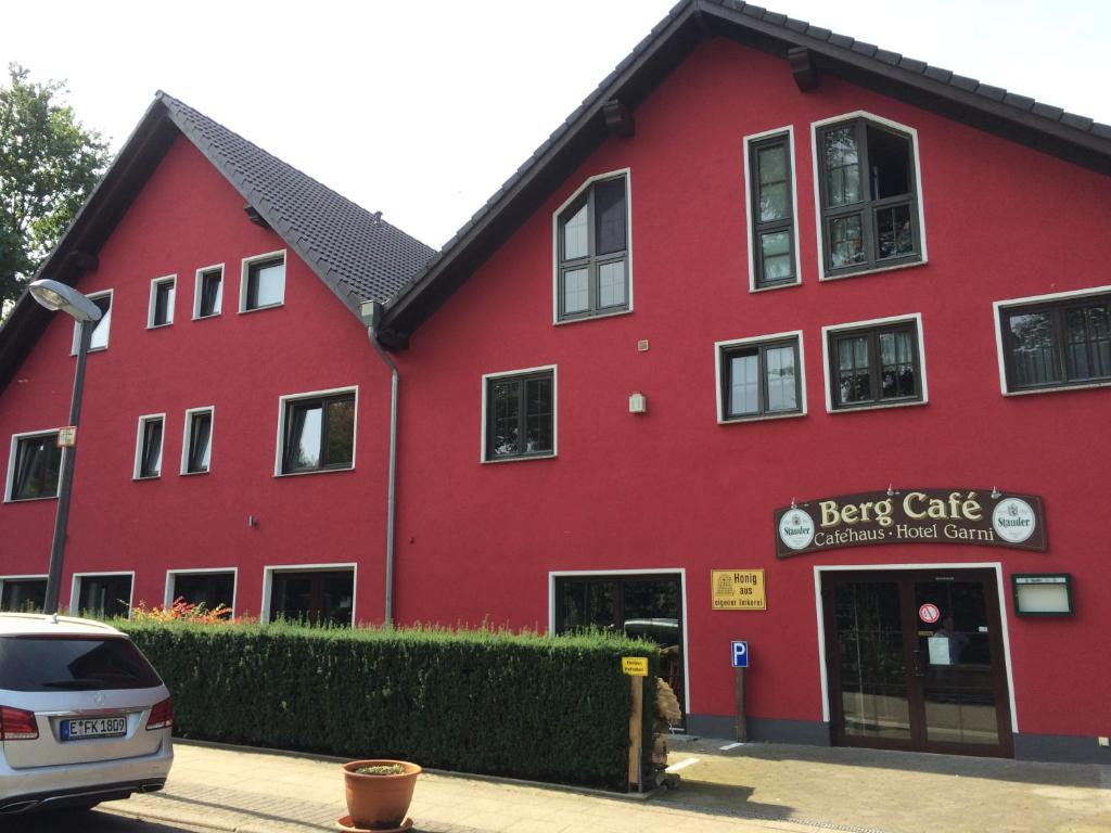 un edificio rosso con un'auto parcheggiata di fronte di Bergcafè - Hotel Kammann a Essen