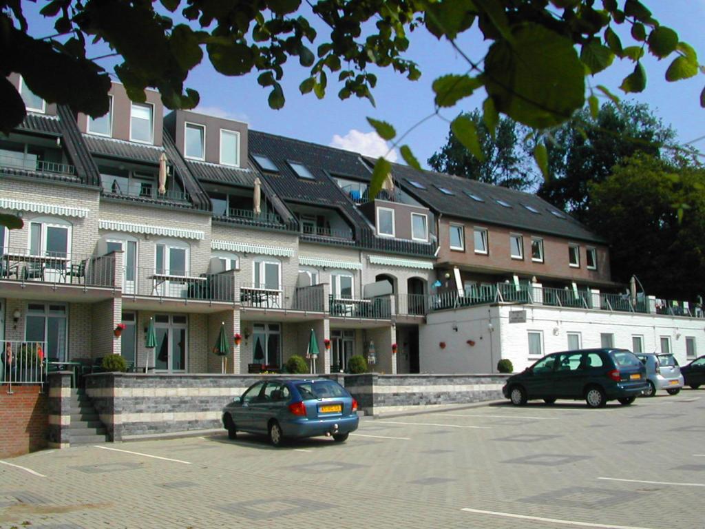 duży budynek z samochodami zaparkowanymi na parkingu w obiekcie paNOORama appartementen w mieście Noorbeek