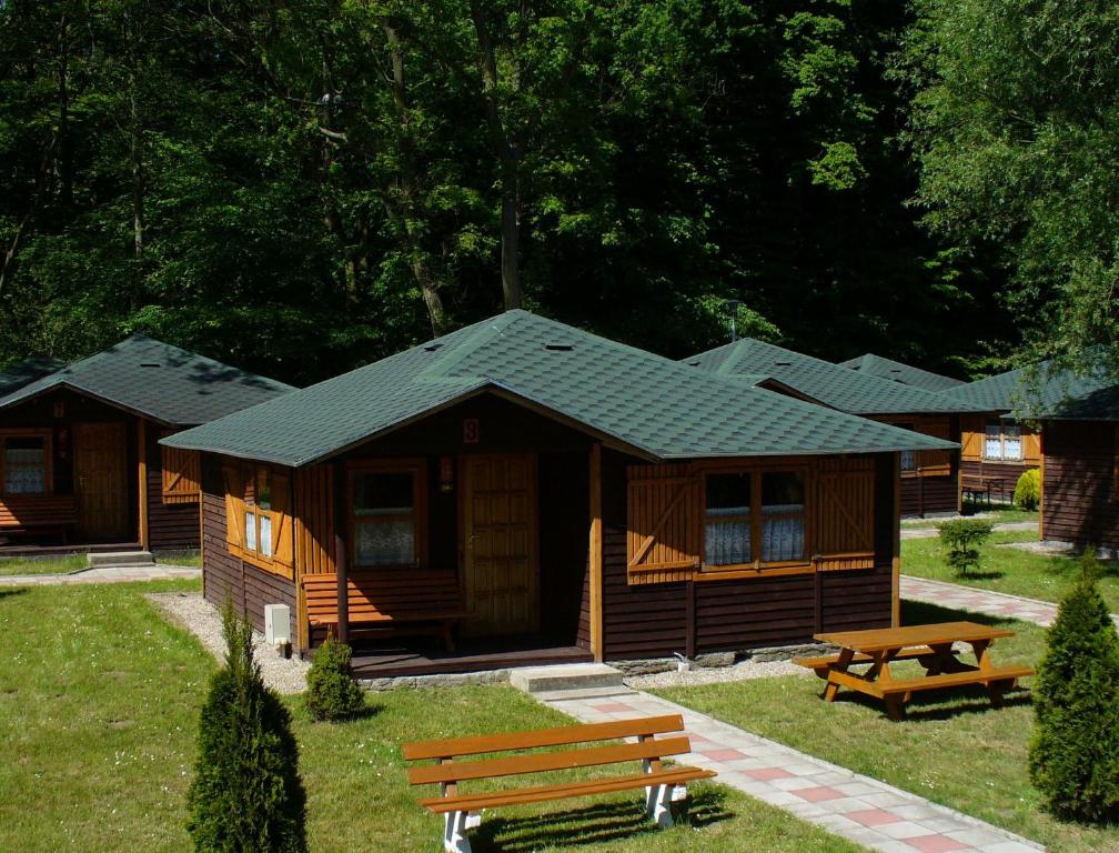 Cabaña de madera con mesa de picnic y bancos en Camping Baltic, en Kołobrzeg