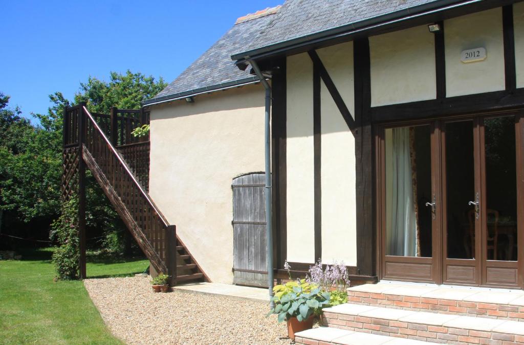 a house with a wooden door and a staircase at Les Bouts de Rallé Chambre d&#39;Hotes in Sainte-Osmane