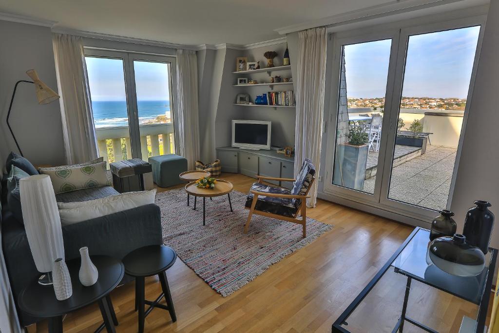 a living room with a view of the ocean at APPARTEMENT PISCINE TERRASSE 1 MIN PLAGE et GOLF in Bidart