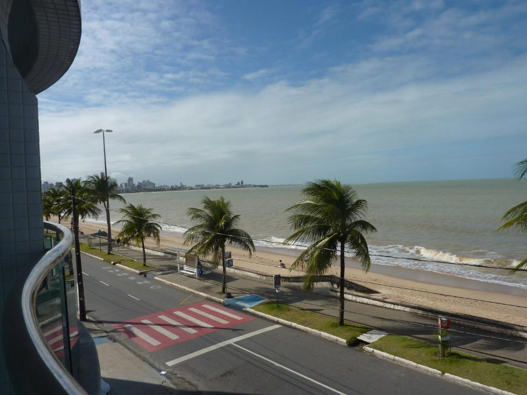 vistas a una playa con palmeras y al océano en Manaira Palace Residence, en João Pessoa