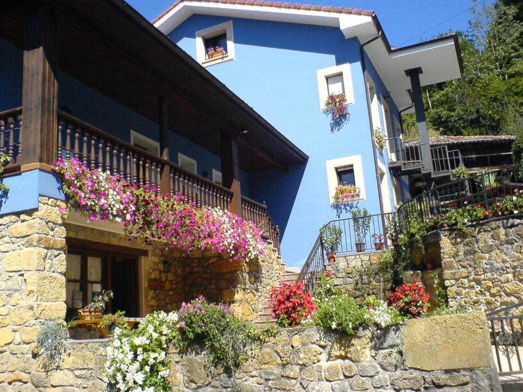 une maison avec des fleurs sur son côté dans l'établissement La Casona de Cardes, à Cangas de Onís