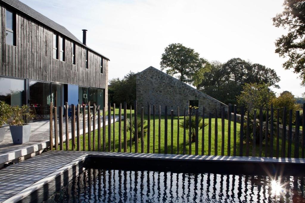 una casa con piscina junto a una valla en Le Clos du Gusquel en Plescop