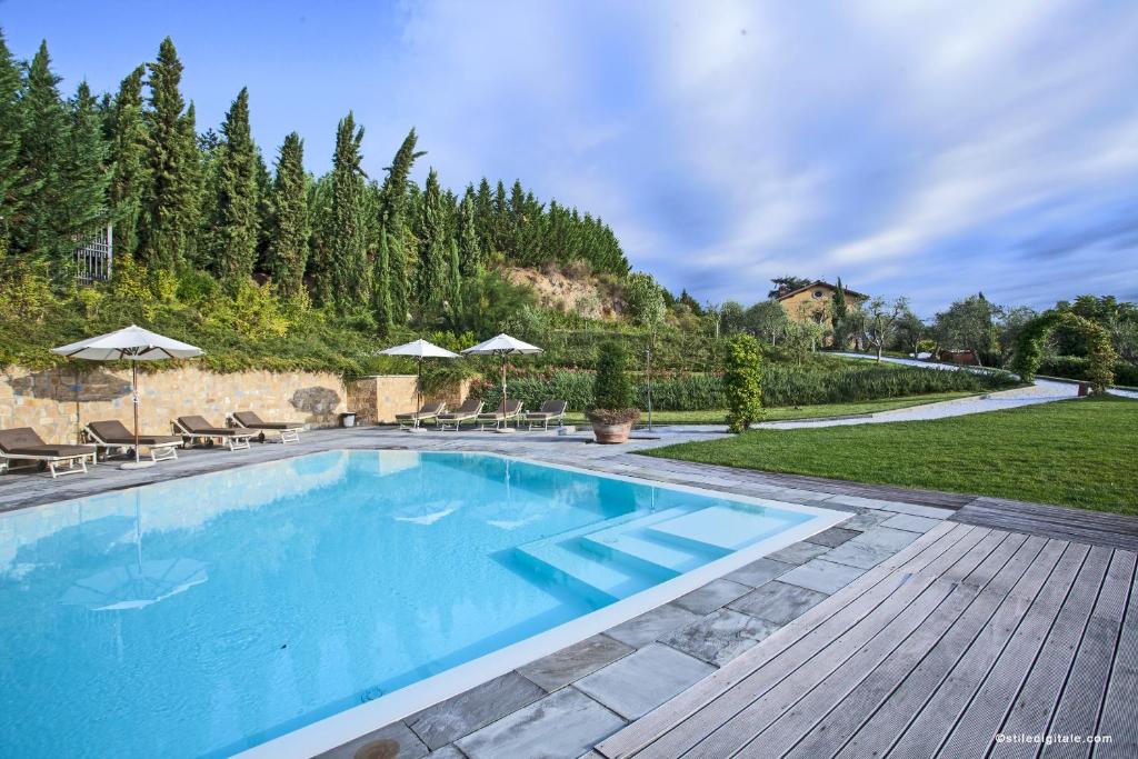 einen Pool mit Stühlen und Sonnenschirmen im Hof in der Unterkunft Relais Villa Belvedere in Incisa in Valdarno