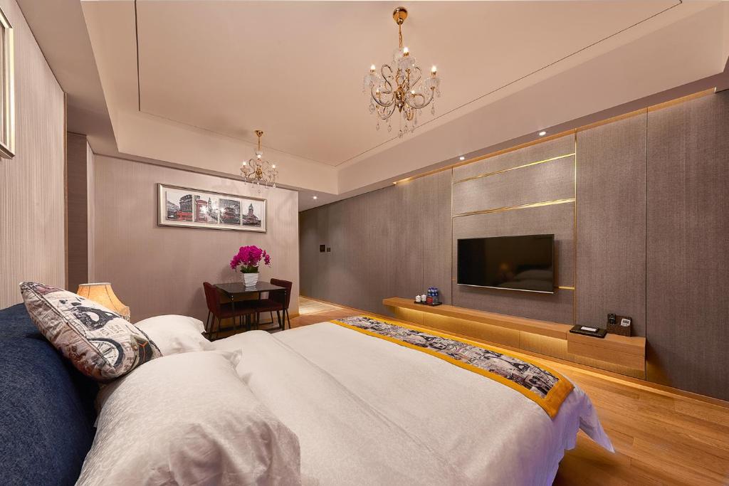 a bedroom with a large bed and a flat screen tv at Heefun International Apartment - Zhujiang New Town FuLi Brand New World Plaza in Guangzhou