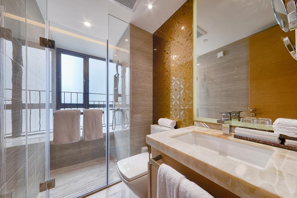 uma casa de banho com um lavatório e uma cabina de duche em vidro. em Heefun Apartment Guangzhou - FuLi Brand New World Plaza em Guangzhou