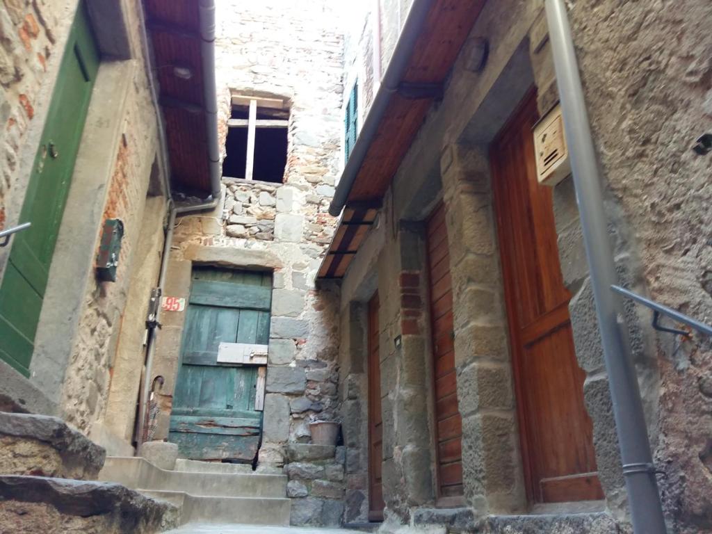Une allée avec une porte bleue dans un ancien bâtiment dans l'établissement La Ginestra, à Corniglia