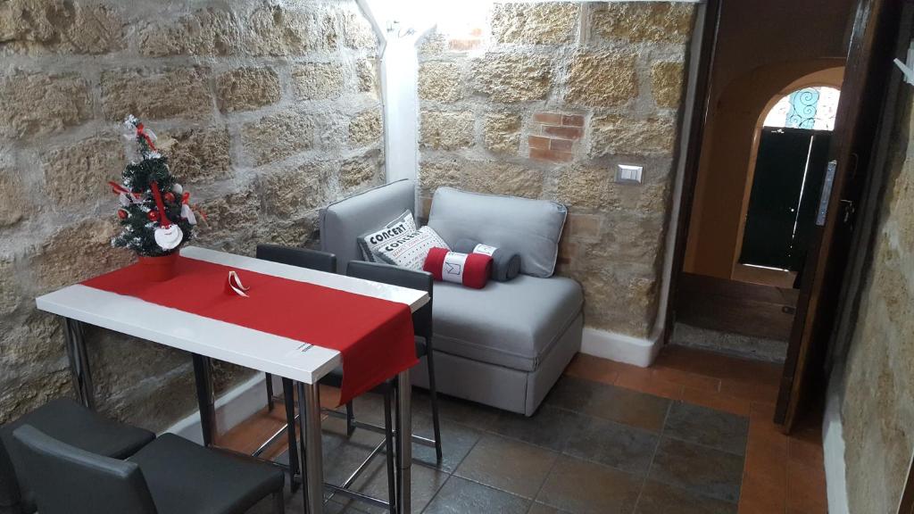 een woonkamer met een tafel, een stoel en een bank bij Brick Apartment in Palermo