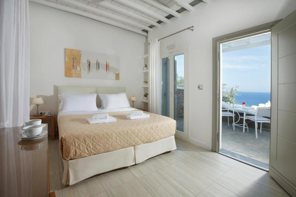 a bedroom with a bed and a view of the ocean at Selana Suites in Chrisopigi