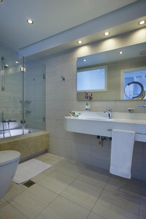 a bathroom with a tub and a sink and a toilet at Selana Suites in Chrisopigi