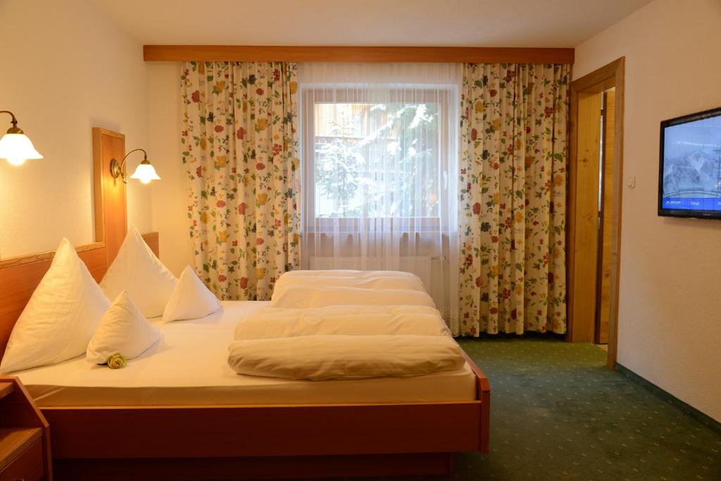 Postel nebo postele na pokoji v ubytování "Quality Hosts Arlberg" Hotel Garni Mössmer