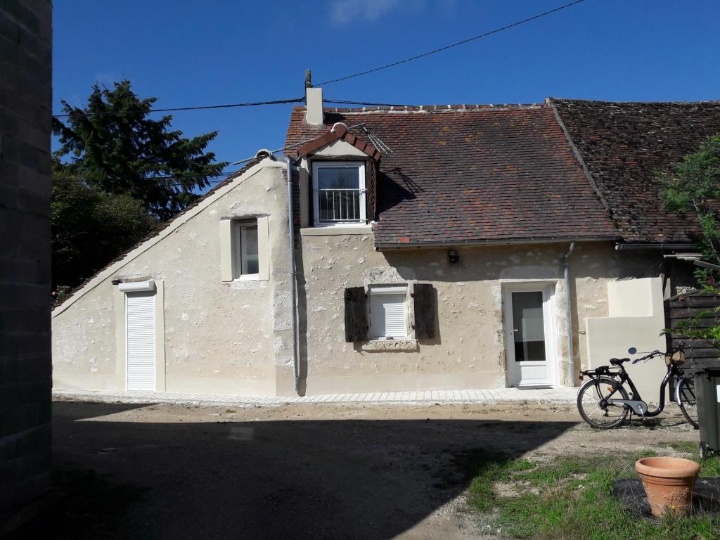 a white house with a bike parked in front of it at Maison De Charme in Cellettes