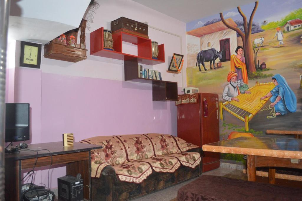 a living room with a couch and a painting on the wall at Azure Family Paying Guest House in Varanasi
