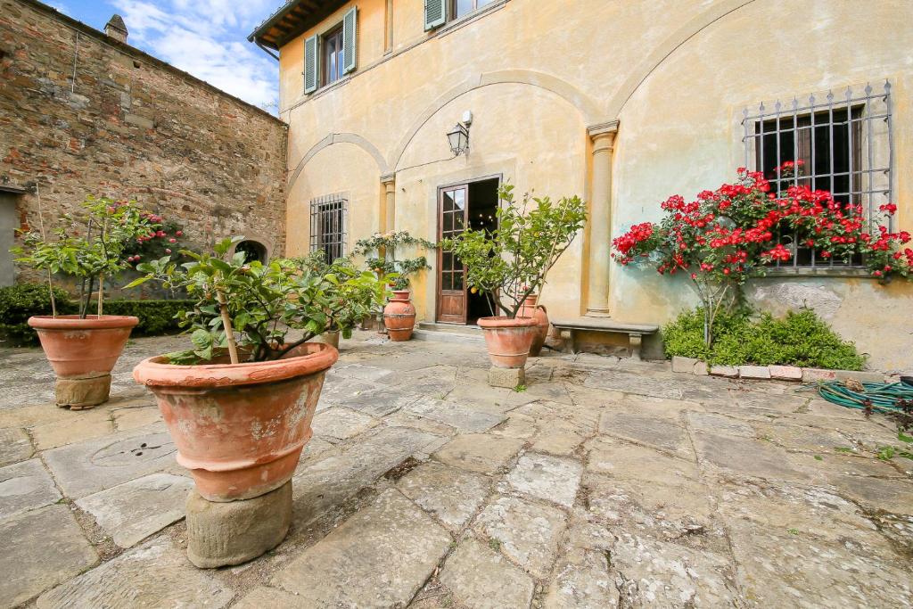 Villa Le Pergole- Firenze في فلورنسا: مجموعة من النباتات الفخارية أمام المبنى