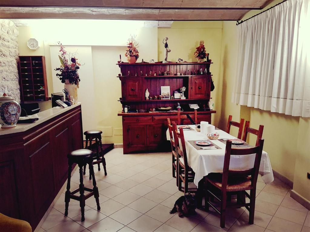 una sala da pranzo con tavolo, sedie e bancone di Hotel Ponte San Vittorino ad Assisi