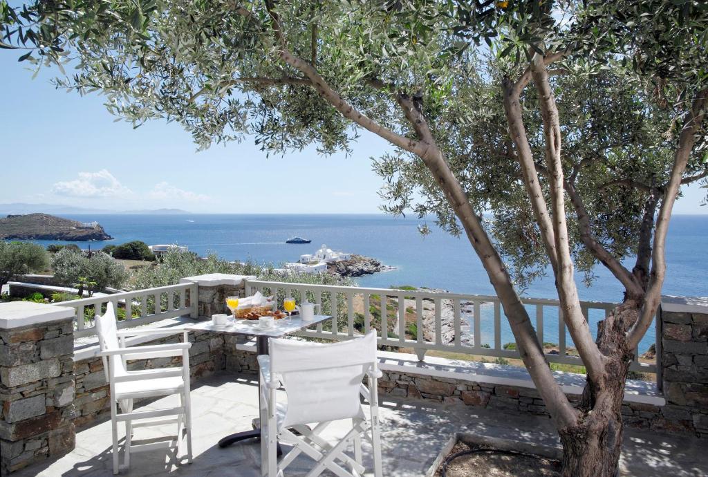 a table and chairs on a balcony with a view of the ocean at Selana Suites in Chrisopigi