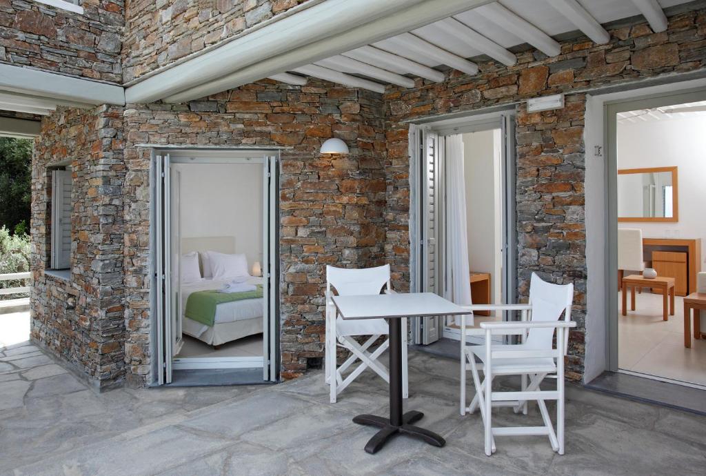 a patio with a table and chairs and a bedroom at Selana Suites in Chrisopigi