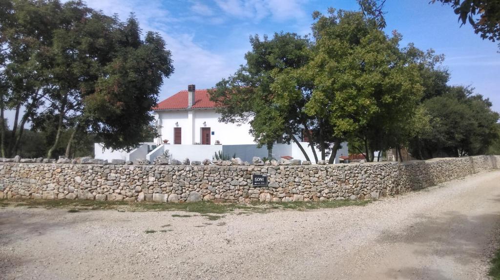 una pared de piedra junto a una casa blanca en House Soni, en Rovinj
