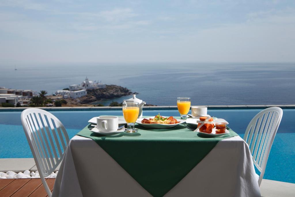 a table with a plate of food and orange juice at Selana Suites in Chrisopigi