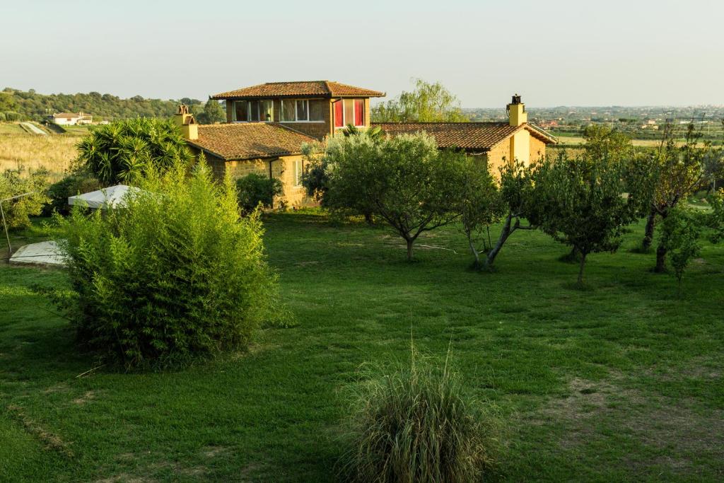 a house in the middle of a field with trees at Le Cascatelle in Cerveteri