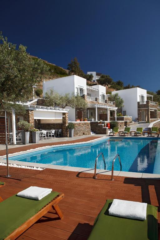 a large swimming pool next to a villa at Selana Suites in Chrisopigi