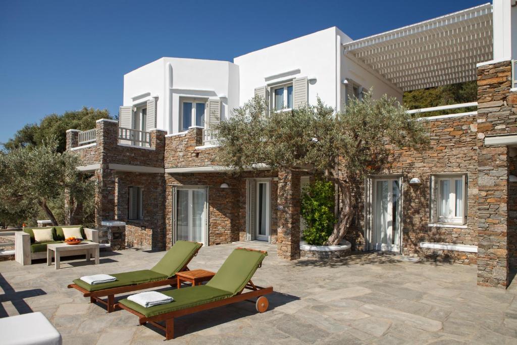 a patio with lounge chairs and a building at Selana Suites in Chrisopigi