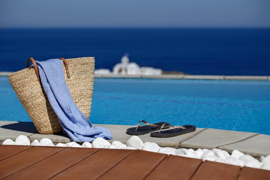 a pair of sandals and a purse next to a pool at Selana Suites in Chrisopigi