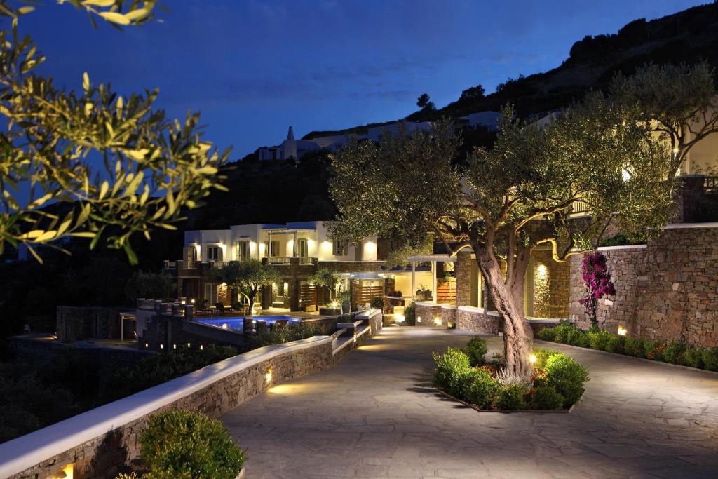 a night view of a building with a tree at Selana Suites in Chrisopigi