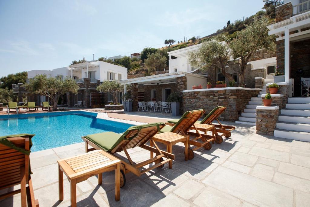 a villa with a swimming pool and some chairs at Selana Suites in Chrisopigi