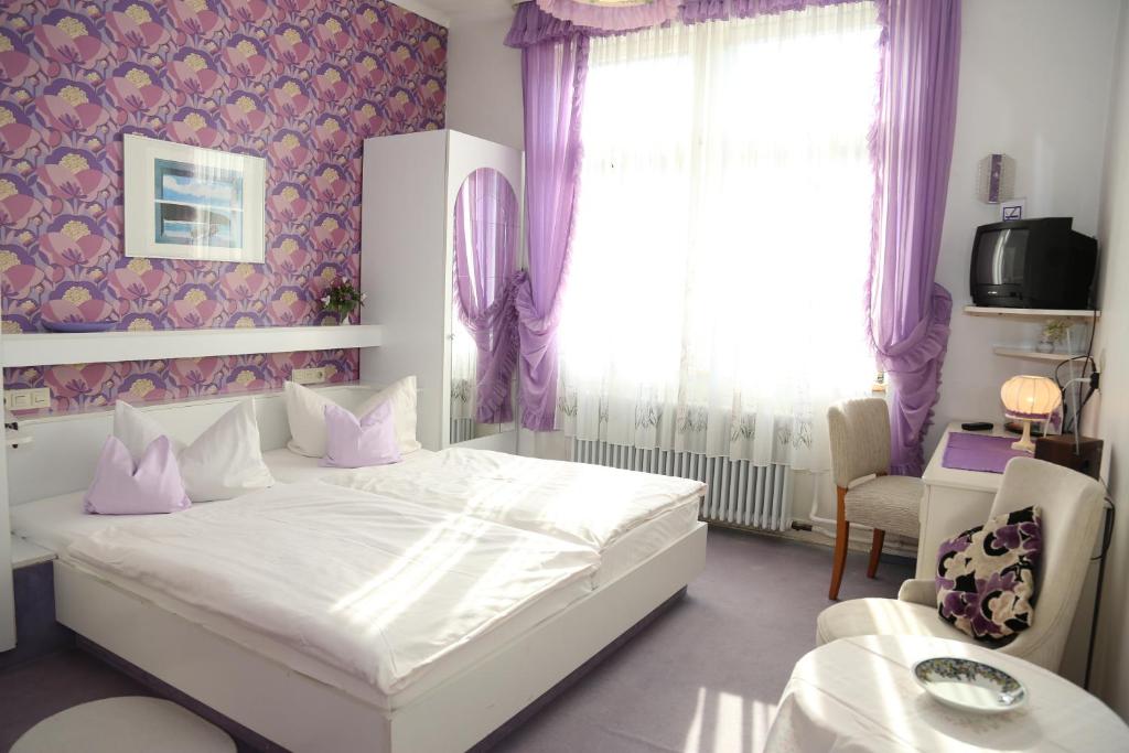 巴登韋勒的住宿－HOTEL YOGA JASMIN ehemals Hotel Eberhardt-Burghardt，卧室配有白色的床和窗户。