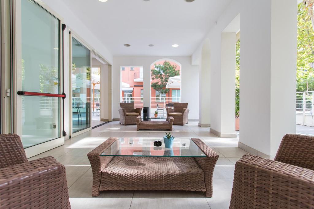 a living room with wicker chairs and a glass table at Wally Residence in Rimini
