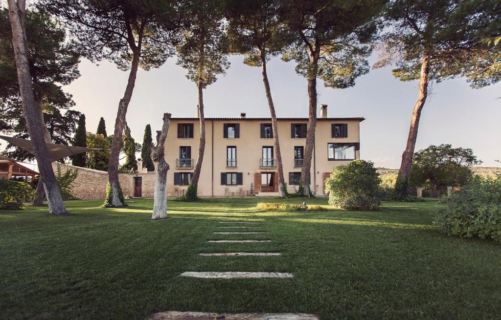 a large house with trees in front of a yard at MasQi, The Energy House in Banyeres de Mariola