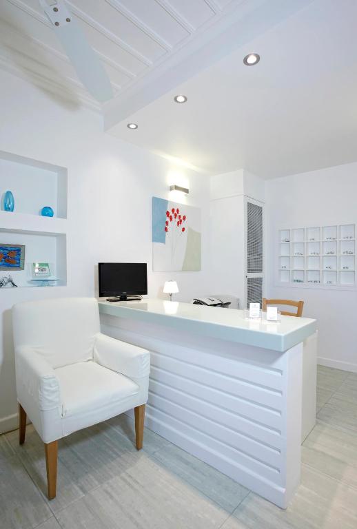 a white office with a white chair and a desk at Selana Suites in Chrisopigi