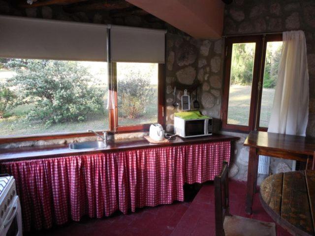 una cocina con mesa y microondas. en La moradita cabañas en Nono