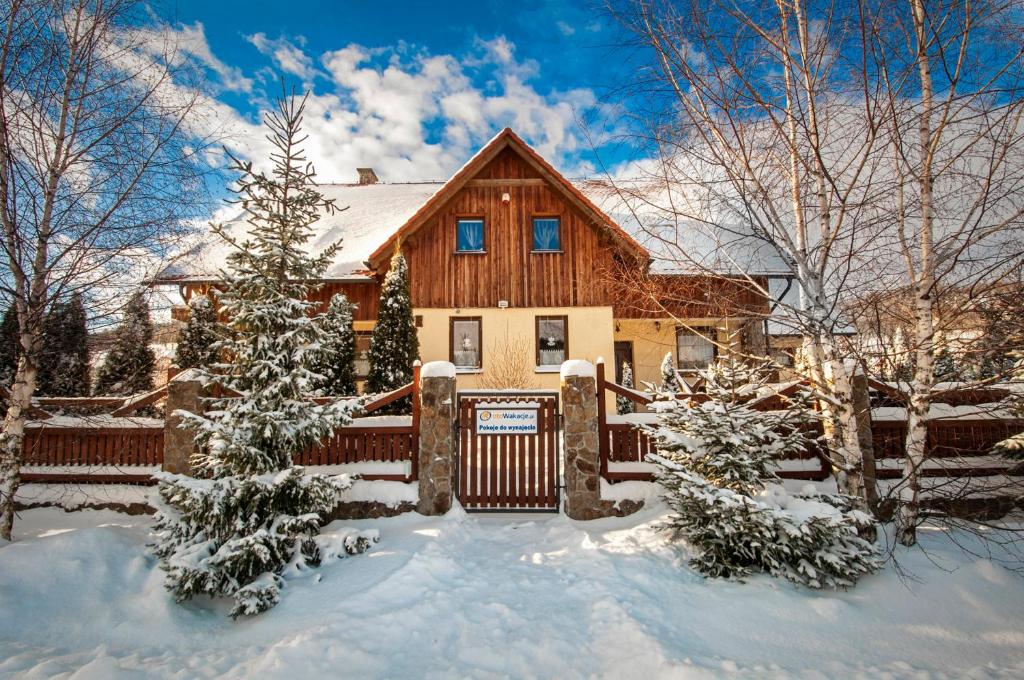 a house with a fence in the snow at Dom pod Wilczyńcem in Stronie Śląskie